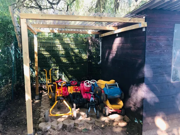 Die fertige Überdachung für die Kinderfahrzeuge im Garten der Kita